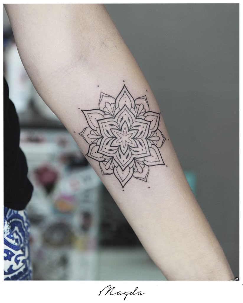 Wzór rozety jako tatuaż geometryczny na przedramieniu