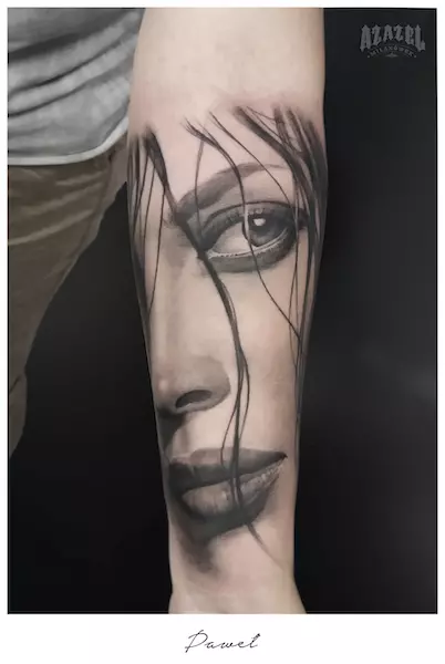 Czarno biały tatuaż realistyczny na ramieniu przedstawiający twarz kobiety