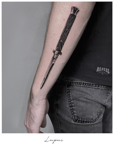 Tatuaż męski przedstawiający nóż na przedramieniu